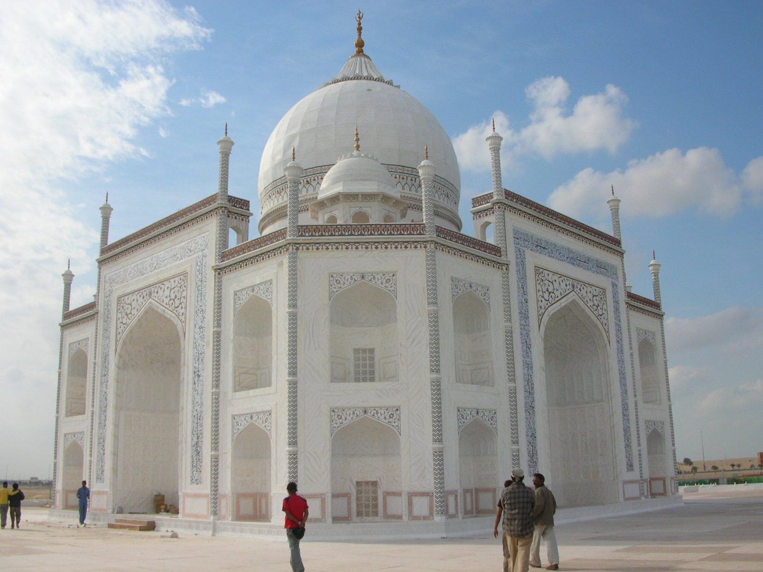 White Taj Mahal replica with people walking around its base