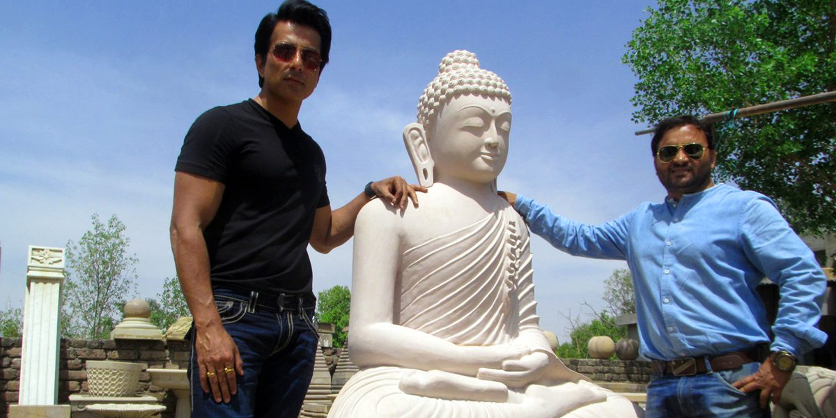 Sonu Sood and Pawan Kumar Bhatt with a white seated Buddha sculpture
